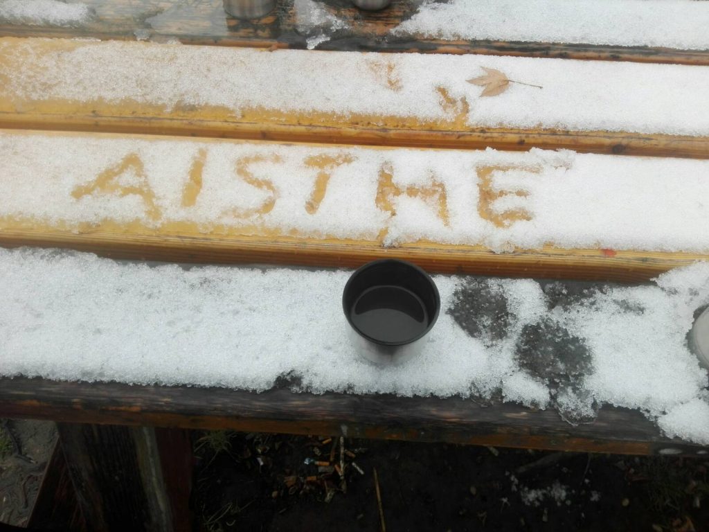 Eine Tasse Tee auf einem Tisch auf dem in den Schnee AISTHE geschrieben steht