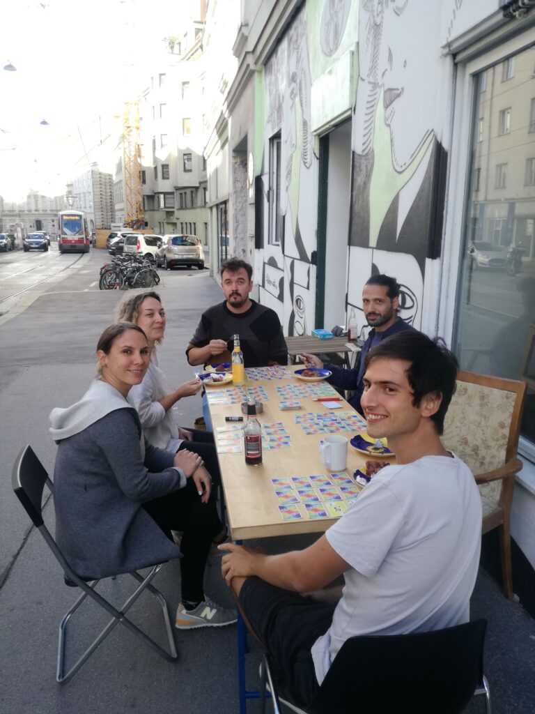 Eine Gruppe sitzt vor dem Vereinslokal und spielt Skyjo.